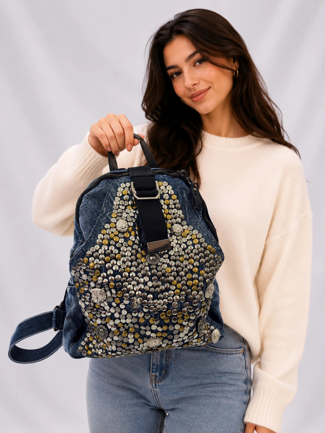 Göz figürlü, zımbalı ve zincir detaylı füme denim kadın sırt çantası. Alternatif stil ve günlük kullanım için modern tasarım Marmoza’da.