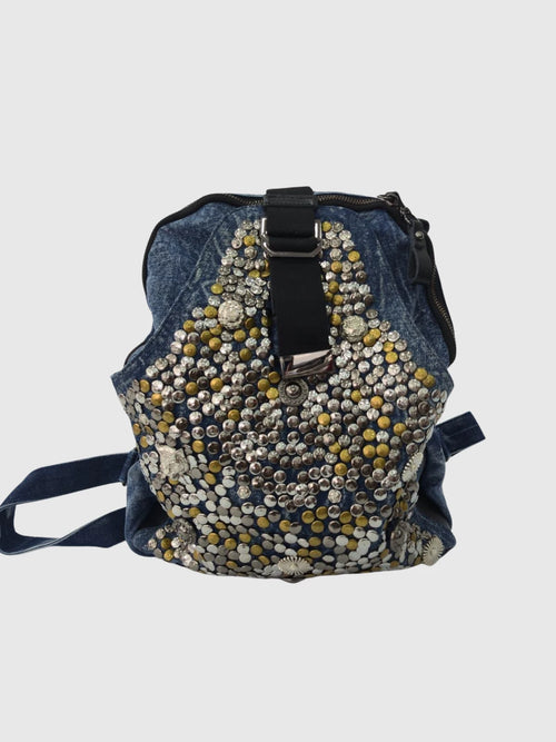 Göz figürlü, zımbalı ve zincir detaylı füme denim kadın sırt çantası. Alternatif stil ve günlük kullanım için modern tasarım Marmoza’da.
